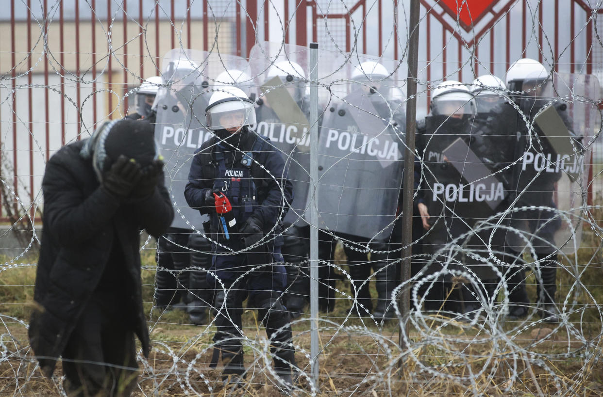 Polish servicemen spray tear gas during clashes with migrants and Polish border guards at the Belarus-Poland border near Grodno, Belarus, on Tuesday, Nov. 16, 2021. Polish border forces say they were attacked with stones by migrants at the border with Belarus and responded with a water cannon. The Border Guard agency posted video on Twitter showing the water cannon being directed across the border at a group of migrants in a makeshift camp. (Leonid Shcheglov/BelTA via AP)