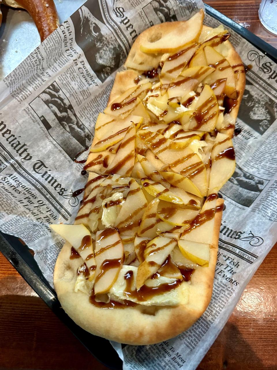 The Pear & Brie flatbread at Tin Whiskey Southern Kitchen and Still in Cocoa Village is topped with brie, onions and thinly sliced, fresh pears, all baked in a brick oven, then drizzled with balsamic reduction.
