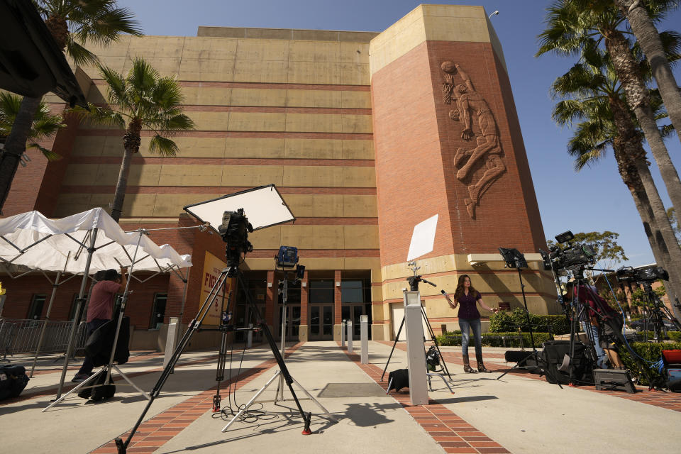 Members of the media gather outside the Galen Center on the campus of the University of Southern California, Tuesday, July 25, 2023, in Los Angeles. Bronny James, the oldest son of NBA superstar LeBron James, was hospitalized after going into cardiac arrest while participating in a practice at the University of Southern California, a family spokesman said Tuesday. The spokesman said medical staff treated the 18-year-old James on site at USC's Galen Center on Monday morning. He was transported to a hospital, where he was in stable condition Tuesday after leaving the intensive care unit. (AP Photo/Damian Dovarganes)