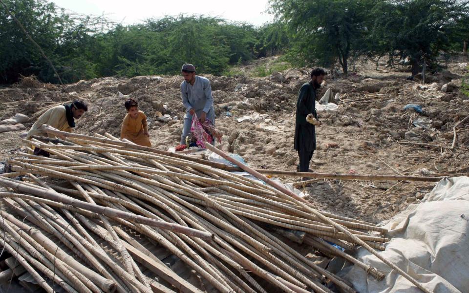 People affected by floods wait for relief at a temporary shelter on the outskirts of Dera Ismail Khan district, Khyber Pakhtunkhwa, Pakistan - SAOOD REHMAN/EPA-EFE/Shutterstock