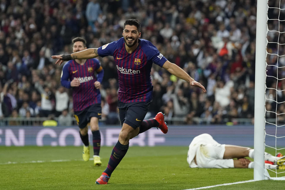 Barcelona forward Luis Suarez celebrates after Real defender Raphael Varane scores an own goal during the Copa del Rey semifinal second leg soccer match between Real Madrid and FC Barcelona at the Bernabeu stadium in Madrid, Spain, Wednesday Feb. 27, 2019. (AP Photo/Andrea Comas)