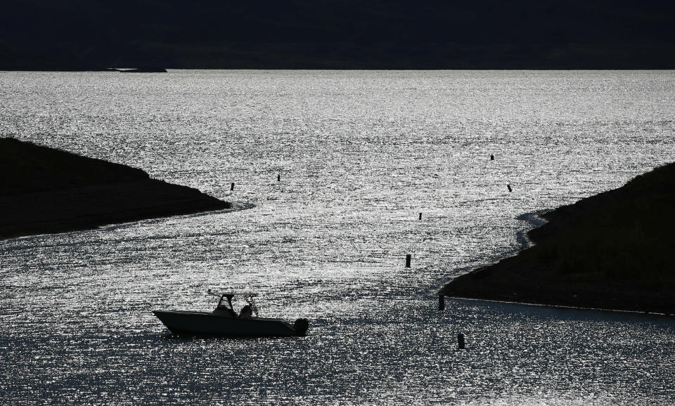 FILE--In this May 19, 2016, file photo, a boater drifts toward a boat ramp in an area that was once underwater at the Lake Mead National Recreation Area near Las Vegas, Nev. California and Arizona have missed a federal deadline for seven Western states to wrap up work on a plan to ensure the drought-stricken Colorado River can deliver water to millions of people who depend on it. (AP Photo/John Locher, file)