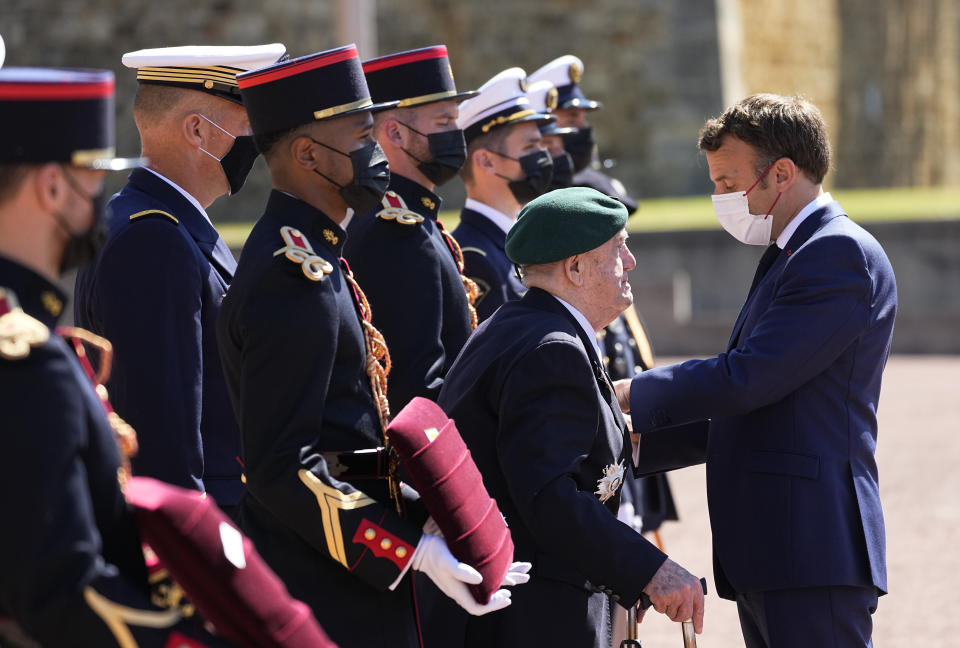 WWII French veterans Leon Gautier, 98 years old last survivor of the Kieffer Commando, left, is honored by French President Emmanuel Macron with the Legion of Honor during a WWII ceremony to mark the 81st anniversary of late French Gen. Charles de Gaulle's resistance call from London on June 18, 1940, at the Mont Valerien, in Suresnes, near Paris, Friday, June 18, 2021. The appeal, which was delivered on the BBC by Charles de Gaulle, served to rally his countrymen after the fall of France to Nazi Germany. (AP Photo/Michel Euler, Pool)