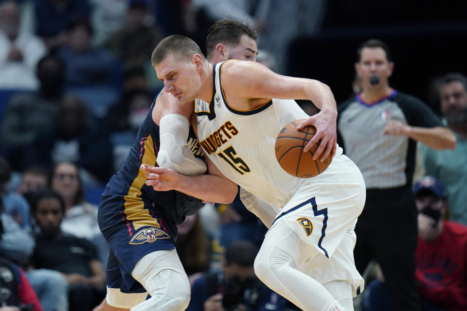 Denver Nuggets center Nikola Jokic (15) drives to the basket against New Orleans Pelicans center Jonas Valanciunas during overtime of an NBA basketball game in New Orleans, Wednesday, Dec. 8, 2021. The Nuggets won 120-114. (AP Photo/Gerald Herbert)