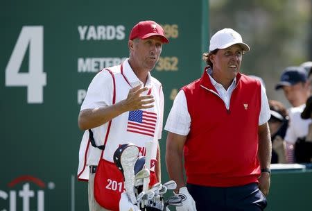 U.S. team member Phil Mickelson (R) talks with his caddie Jim Mackay before teeing off on the fourth hole during the opening foursome matches of the 2015 Presidents Cup golf tournament at the Jack Nicklaus Golf Club in Incheon, South Korea, October 8, 2015. REUTERS/Kim Hong-Ji