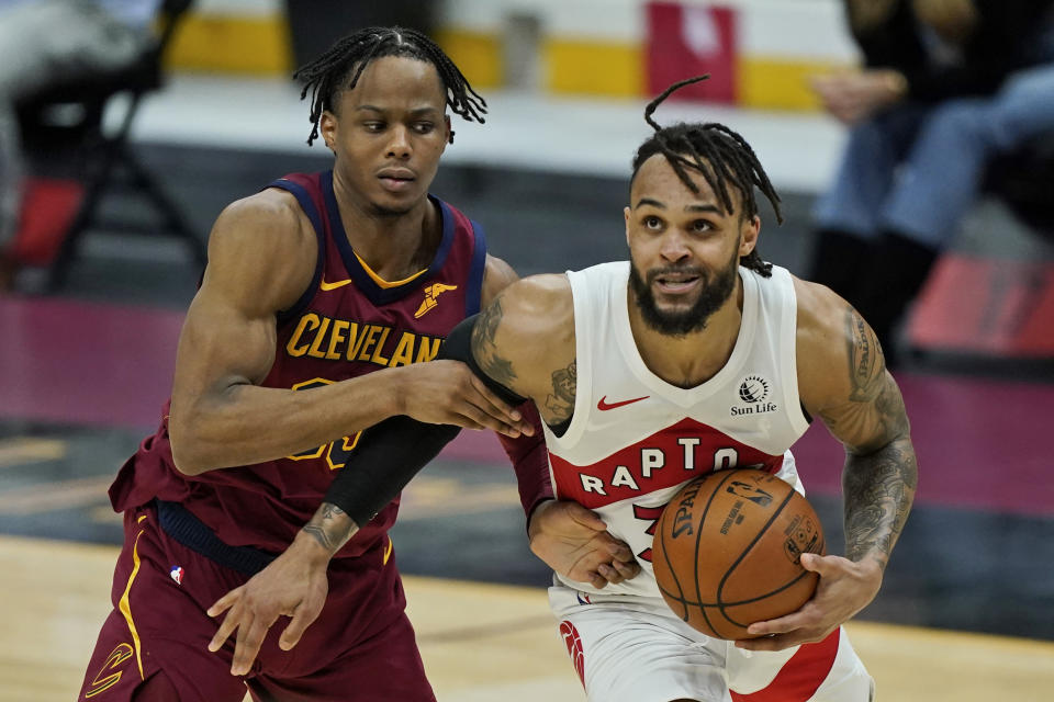 Toronto Raptors' Gary Trent Jr., right, drives to the basket against Cleveland Cavaliers' Isaac Okoro in the second half of an NBA basketball game, Saturday, April 10, 2021, in Cleveland. (AP Photo/Tony Dejak)