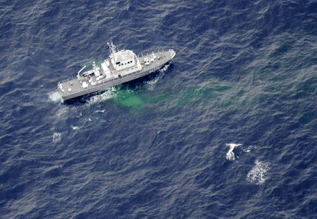 A Japan Coast Guard patrol vessel sails on the water at the area where two U.S. Marine Corps aircraft have been involved in a mishap in the skies, off the coast of Kochi prefecture, Japan, in this aerial view photo taken by Kyodo December 6, 2018. Mandatory credit Kyodo/via REUTERS