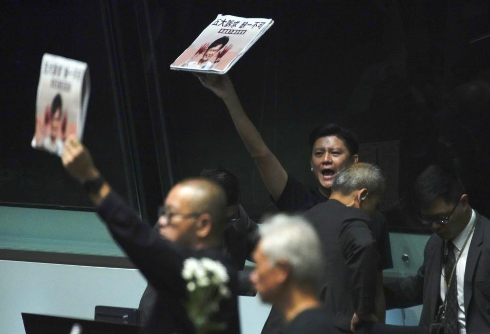 Pro-democracy lawmakers shout a slogan while Hong Kong Chief Executive Carrie Lam arrives at chamber of the Legislative Council in Hong Kong, on Thursday, Oct. 17, 2019. (AP Photo/Vincent Yu)