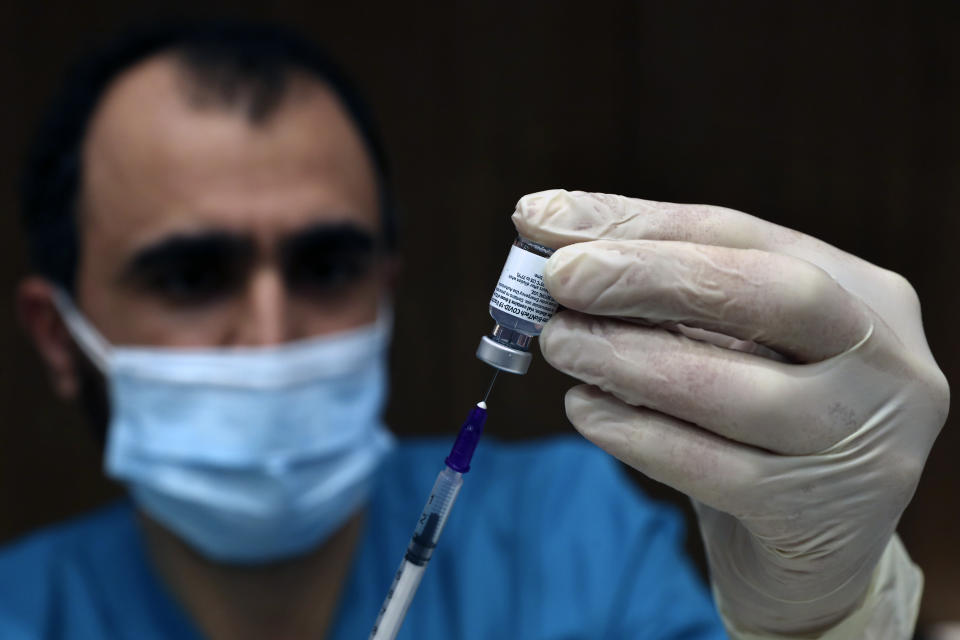 A medic prepares a syringe of the Pfizer-BioNTech COVID-19 vaccine during a nationwide vaccination campaign, at the American University Medical Center in Beirut, Lebanon, Sunday, Feb. 14, 2021. (AP Photo/Bilal Hussein)