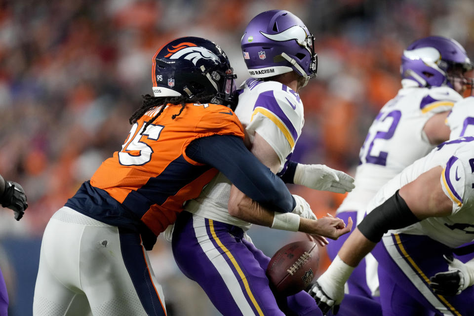 Denver Broncos defensive tackle McTelvin Agim (95) knocks the ball away from Minnesota Vikings quarterback Sean Mannion (14) during the first half of an NFL preseason football game, Saturday, Aug. 27, 2022, in Denver. The Broncos recovered the ball for a touchdown. (AP Photo/David Zalubowski)