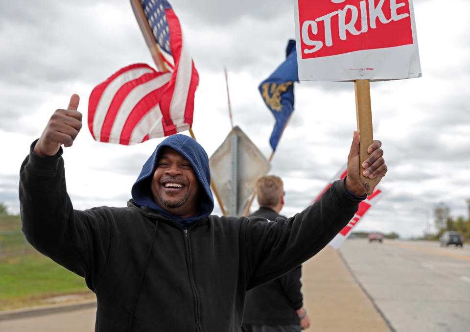 Bill Jackson, of St. Louis, gives a thumbs up to drivers that wave or honk as United Auto Workers outside the GM Wentzville Assembly Center in Wentzville, Mo., Wednesday, Oct. 16, 2019. UAW workers have been on strike since Sept. 16, but have reached a tentative deal with GM today. Workers expressed cautious optimism, but will likely remain on the picket line until an official deal has been reached. (Cristina M. Fletes/St. Louis Post-Dispatch via AP)