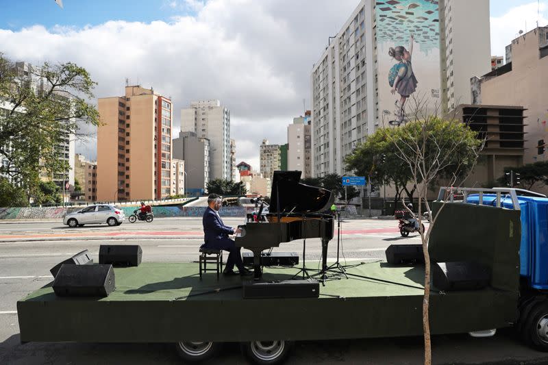 Pianist Rodrigo Cunha serenades from an open truck, in Sao Paulo