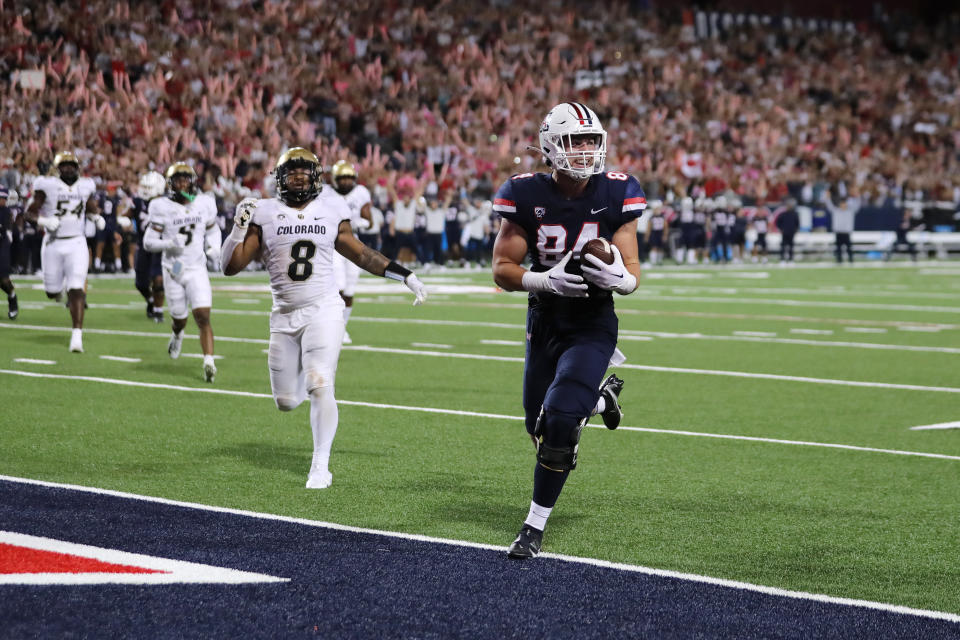 TUCSON, ARIZONA – OCTOBER 01: Tight end Tanner McLachlan #84 of the <a class="link " href="https://sports.yahoo.com/ncaaw/teams/arizona/" data-i13n="sec:content-canvas;subsec:anchor_text;elm:context_link" data-ylk="slk:Arizona Wildcats;sec:content-canvas;subsec:anchor_text;elm:context_link;itc:0">Arizona Wildcats</a> grins as he crosses into the end zone for a touchdown during the first half of the NCAA football game against the Colorado Buffalo at Arizona Stadium on October 01, 2022 in Tucson, <a class="link " href="https://sports.yahoo.com/ncaaw/teams/arizona/" data-i13n="sec:content-canvas;subsec:anchor_text;elm:context_link" data-ylk="slk:Arizona;sec:content-canvas;subsec:anchor_text;elm:context_link;itc:0">Arizona</a>. (Photo by Rebecca Noble/Getty Images)