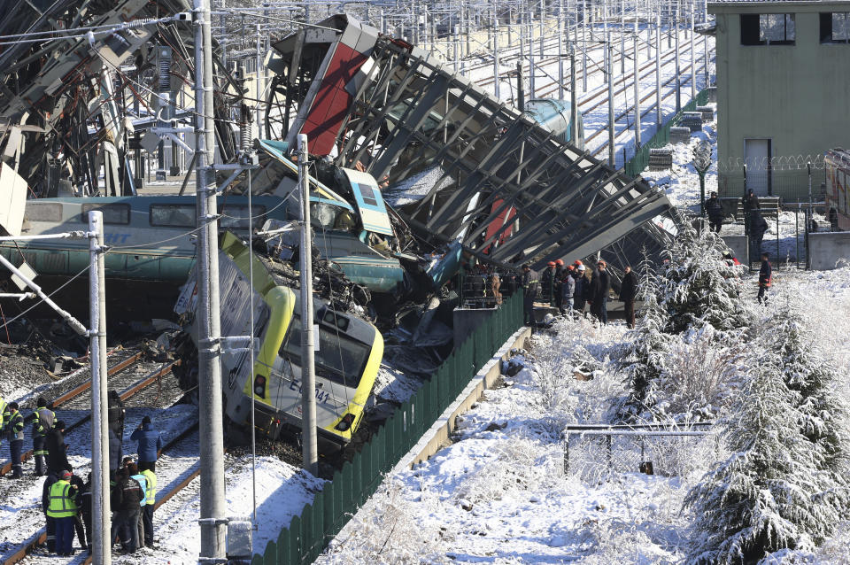 Members of rescue services work at the scene of a train accident in Ankara, Turkey, Thursday, Dec. 13, 2018. A high-speed train hit a railway engine and crashed into a pedestrian overpass at a station in the Turkish capital Ankara on Thursday, killing more than 5 people and injuring more than 40 others, officials and news reports said. (AP Photo/Burhan Ozbilici)
