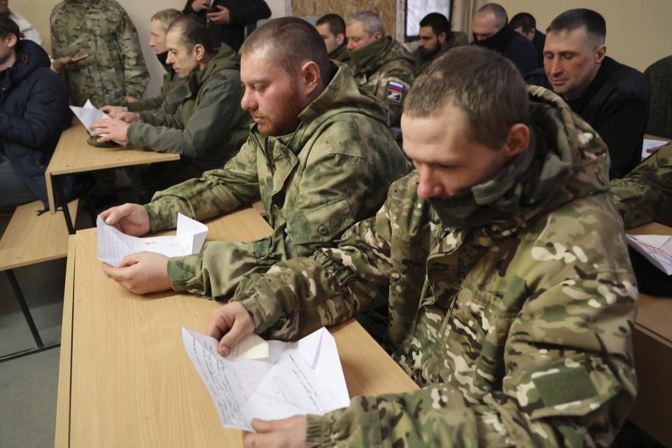 Russian soldiers read letters written by schoolchildren in a gesture of support at an undisclosed location in a Russian-controlled part of the Donetsk region, in eastern Ukraine, Tuesday, Feb. 14, 2023. Schoolchildren are writing to soldiers in Ukraine or make drawings for them. (AP Photo/Alexei Alexandrov)