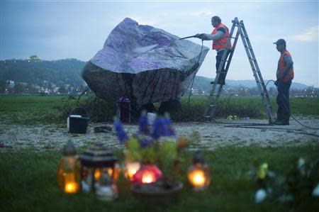 A worker clears away graffiti of the Star of David on the Pope John Paul II memorial boulder in Krakow April 23, 2014. REUTERS/Pawel Ulatowski