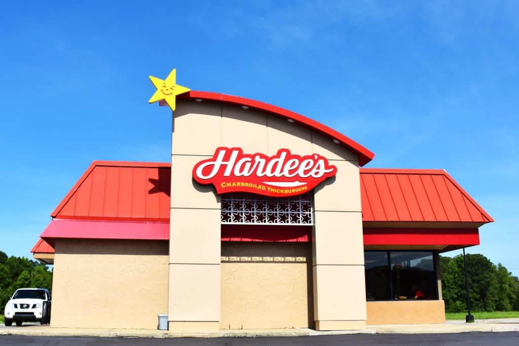 A Hardee's fast food store front is photographed from the outside of the establishment. 