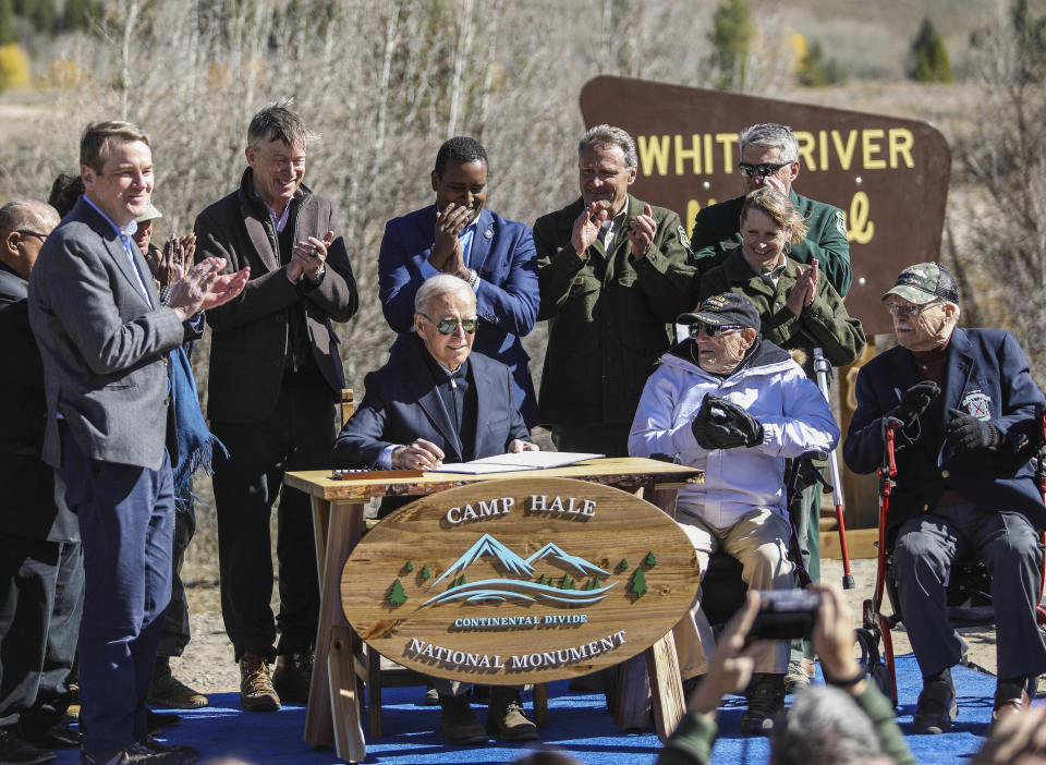 President Joe Biden signs a proclamation to designate the first national monument of his administration at Camp Hale, a World War II-era training site, the Camp Hale - Continental Divide National Monument, on Wednesday, Oct. 12, 2022, in Camp Hale, Colo. The monument is to honor the 10th Mountain Division soldiers who trained there to fight in Italy in World War II. (Chris Dillmann/Vail Daily via AP)
