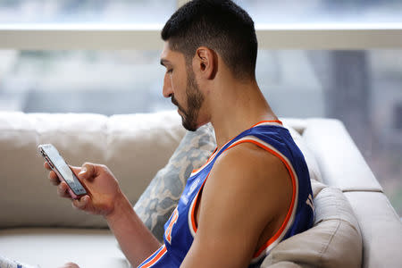 Turkish NBA player Enes Kanter texts a teammate on the New York Knicks, before their game against the Washington Wizards at the O2 Arena in London on television from White Plains, New York, U.S., January 17, 2019. REUTERS/Caitlin Ochs