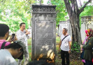 In search of: Sven Verbeek (with microphone) shows the tombstones of his great-great-grandparents at Museum Prastasi.