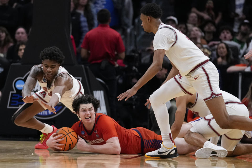 Clemson forward Ian Schieffelin, center, grabs a loose ball next to Alabama forward Nick Pringle, left, during the second half of an Elite 8 college basketball game in the NCAA tournament Saturday, March 30, 2024, in Los Angeles. (AP Photo/Ashley Landis)