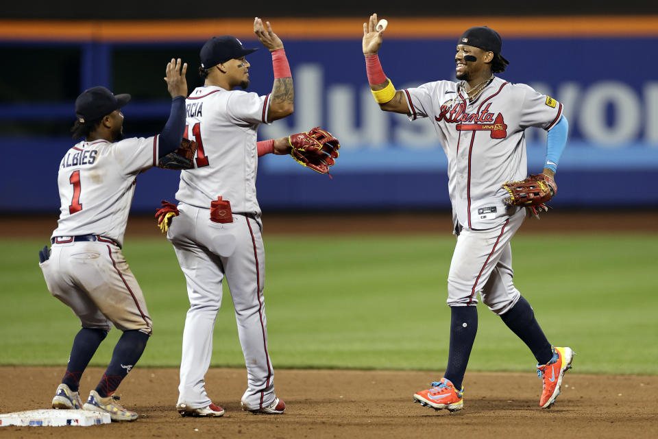 Atlanta Braves right fielder Ronald Acuna Jr., right, celebrates with Orlando Arcia, center, and Ozzie Albies (1) after they defeated the New York Mets in the second baseball game of a doubleheader Saturday, Aug. 12, 2023, in New York. (AP Photo/Adam Hunger)