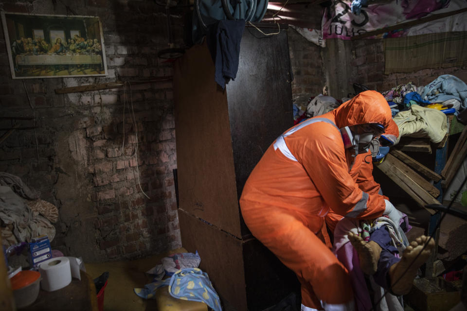 Piedrangel funeral home workers Jhoan Faneite and Luis Brito, both of Venezuela, remove the body of an 85-year-old retired carpenter who is suspected to have died from complications due to the new coronavirus, in the Chorrillos neighborhood of Lima, Peru, Monday, May 4, 2020. According to medical and funeral workers, Peruvians are dying from the virus at home by the hundreds. (AP Photo/Rodrigo Abd)