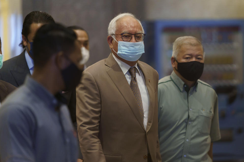 FILE - Former Malaysian Prime Minister Najib Razak, center, wearing a face mask arrives at Court of Appeal in Putrajaya, Malaysia on April 5, 2021. Malaysia’s Appeal Court on Wednesday, Dec. 8, 2021, upheld the conviction of ex-Prime Minister Najib Razak linked to the massive looting of the 1MDB state investment fund that brought down his government in 2018. (AP Photo/Vincent Thian, File)