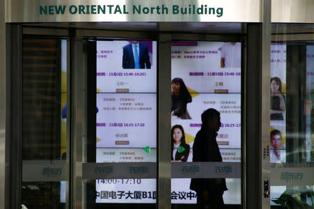 A man walks in the lobby of the headquarters of the New Oriental Education & Technology Group in Beijing, China, November 25, 2016. To match Special Report COLLEGE-CHARITIES/ REUTERS/Thomas Peter