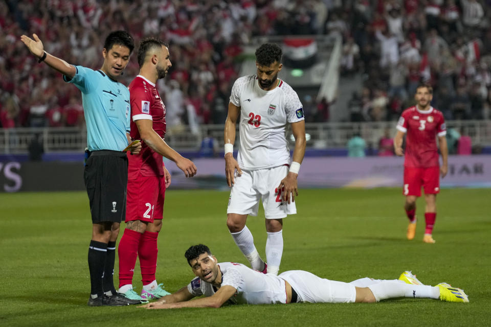 Iran's Mehdi Taremi, down, reacts after being shown a red card during the Asian Cup Round of 16 soccer match between Iran and Syria, at Abdullah Bin Khalifa Stadium in Doha, Qatar, Wednesday, Jan. 31, 2024. (AP Photo/Aijaz Rahi)
