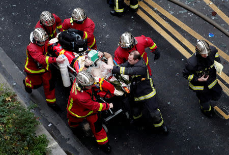 Firemen wheel a stretcher carrying a man injured in an explosion in a bakery shop in the 9th District in Paris, France, January 12, 2019 REUTERS/Benoit Tessier