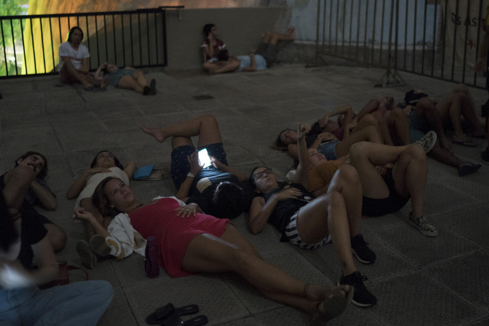 People watch the blood moon from the rooftop of a planetarium in Rio de Janeiro, Jan. 21.