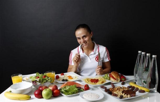 Turkish wrestler and Olympic hopeful Elif Jale Yesilirmak, 26, poses in front of her daily meal intake in Ankara May 29, 2012.