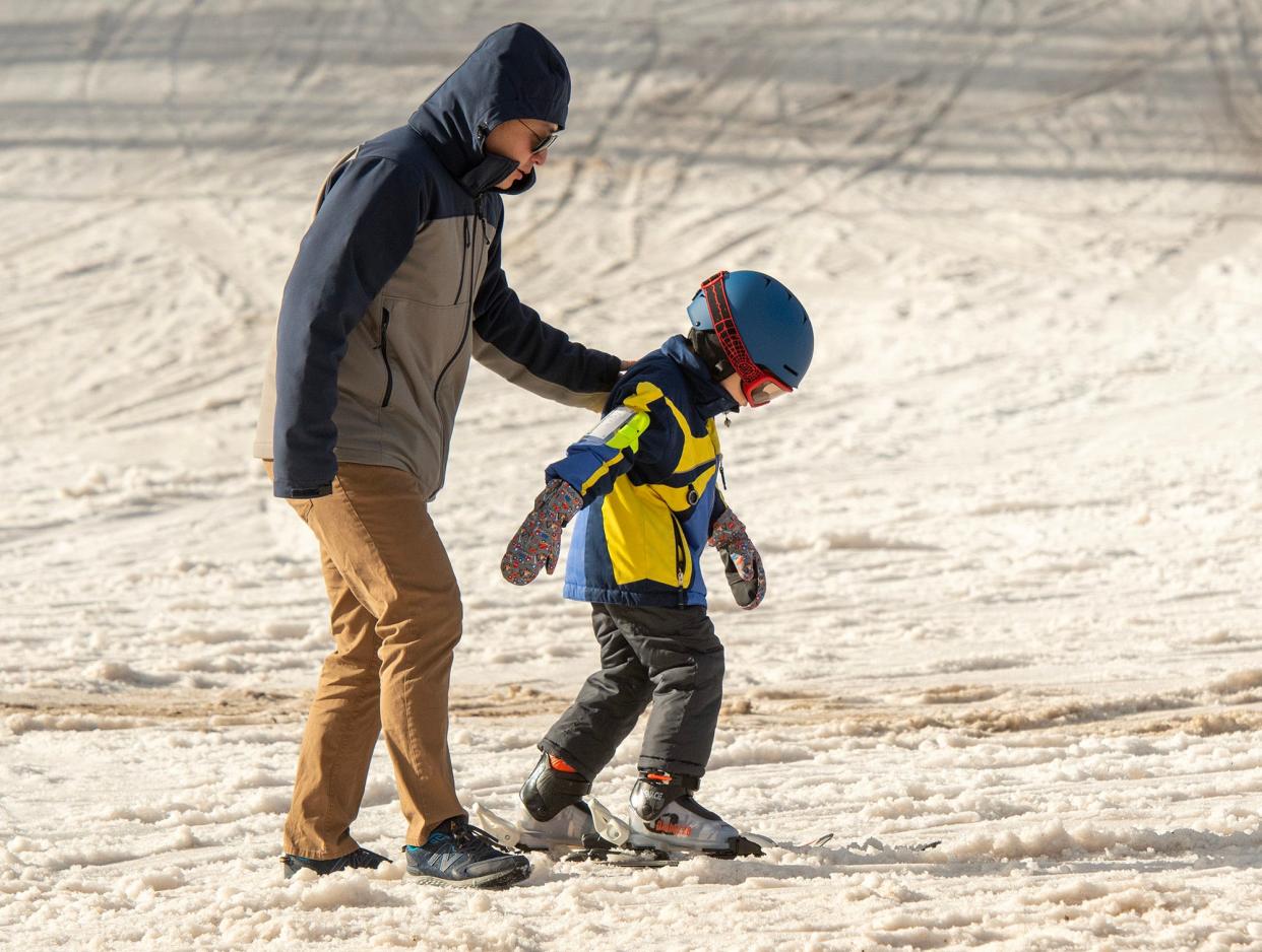 Jeff Wang of Arlington encourages his 5-year-old son, Felix, as the boy skis for the first time at Wachusett Mountain Tuesday.