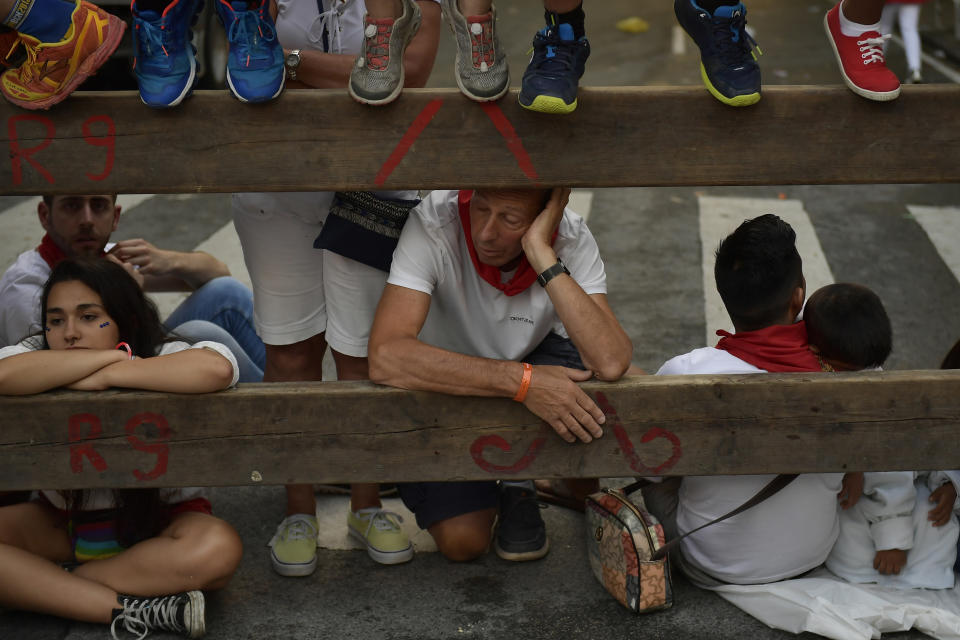 <p>A man sleeps while waiting for the start of the 4th day of the running of the bulls at the San Fermin Festival in Pamplona, northern Spain, July 10, 2018. (Photo: Alvaro Barrientos/AP) </p>