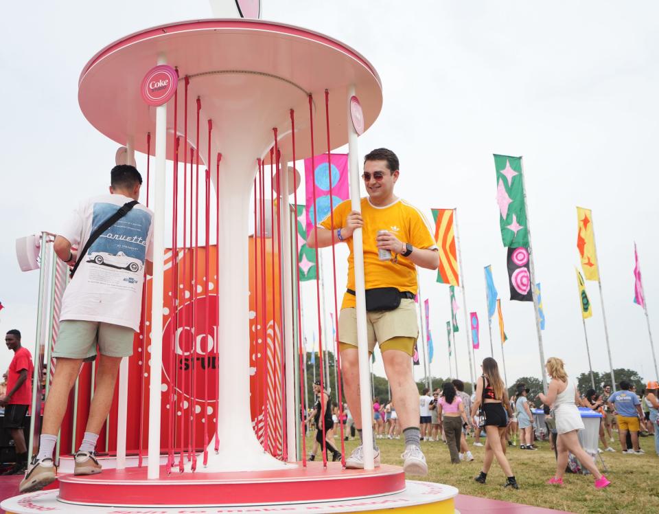 Omar Ramirez, left, and Matt Gamboa, right, swing Friday at the Coke Studio during Austin City Limits Music Festival. Everything in the Coca-Cola activation makes music.