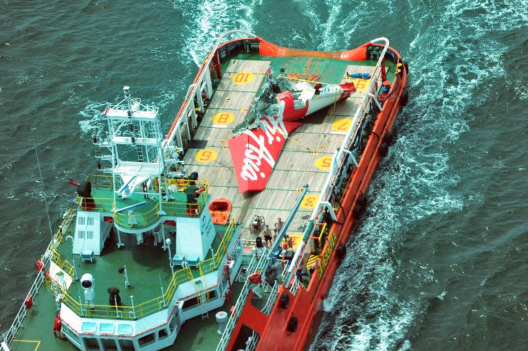 An aerial photo shows a tail section (C) of the AirAsia flight QZ8501 on the deck of a Crest Onyx ship as the search for black boxes of the aircraft continues in the Java sea on January 11, 2015