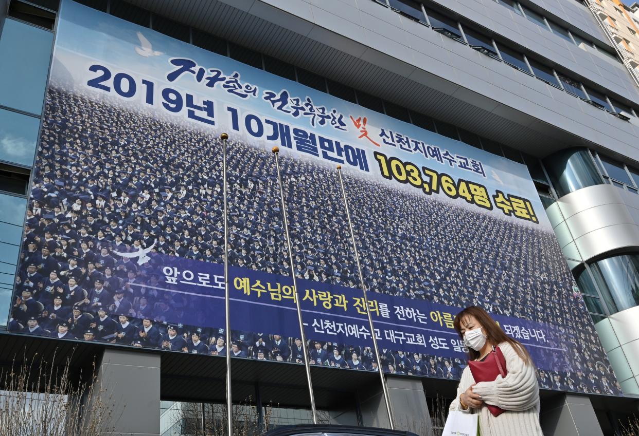 A woman wearing a face mask walks in front of the Daegu branch of the Shincheonji Church of Jesus in Daegu on February 27, 2020. - The secretive South Korean religious group at the centre of the country's new coronavirus outbreak is a sprawling network so wealthy it can mobilise thousands of believers to hold Pyongyang-style mass performances at Seoul's Olympic stadium. More than half of the country's nearly 1,600 infections are linked to Shincheonji followers. (Photo by Jung Yeon-je / AFP) (Photo by JUNG YEON-JE/AFP via Getty Images)