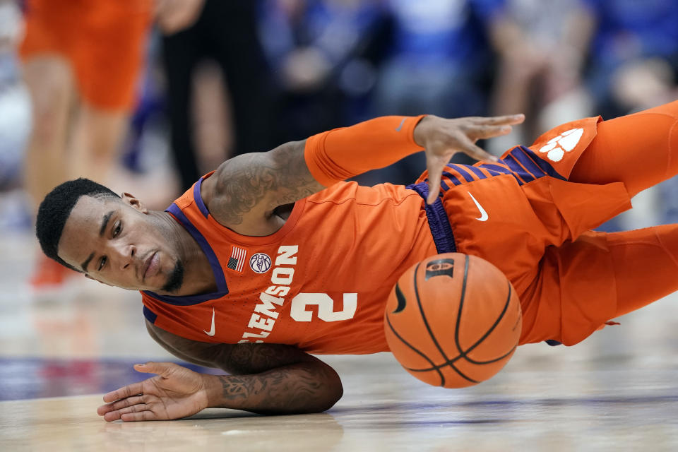 Clemson guard Al-Amir Dawes (2) falls to the floor while chasing the ball during the first half of an NCAA college basketball game against Duke in Durham, N.C., Tuesday, Jan. 25, 2022. (AP Photo/Gerry Broome)