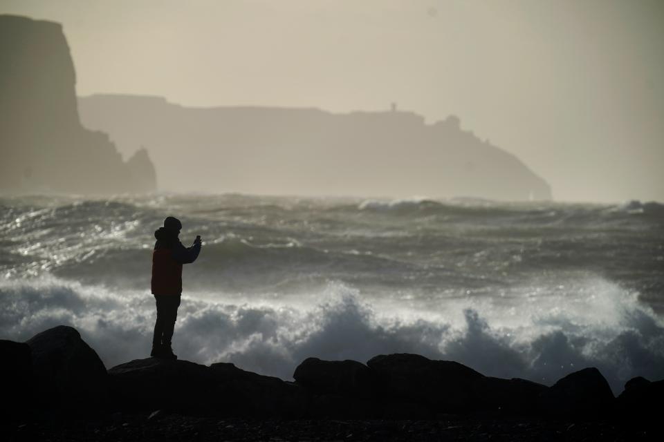 A person watching high waves in Doolin in County Clare on the west coast of Ireland (Niall Carson/PA Wire)