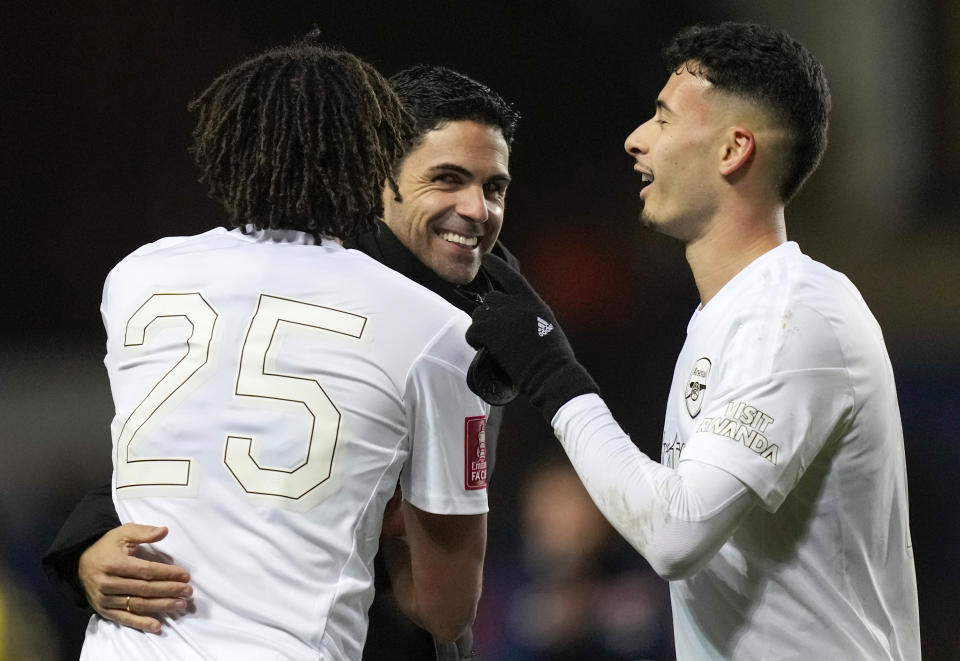 FILE - Arsenal's manager Mikel Arteta, center celebrates with Arsenal's Mohamed Elneny, left, Gabriel Martinelli at the end of the English FA Cup soccer match between Arsenal and Oxford United at the Kassam Stadium in Oxford, Monday, Jan. 9, 2023. Arsenal has revealed new artwork that will be displayed on the exterior of the Emirates Stadium. (AP Photo/Frank Augstein, File)