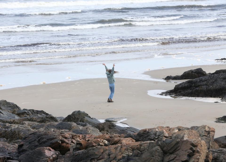 A teenager twirls around near the Atlantic Ocean at Marginal Way, which has reopened to the public. The scenic path in Ogunquit was closed due to storm damage.