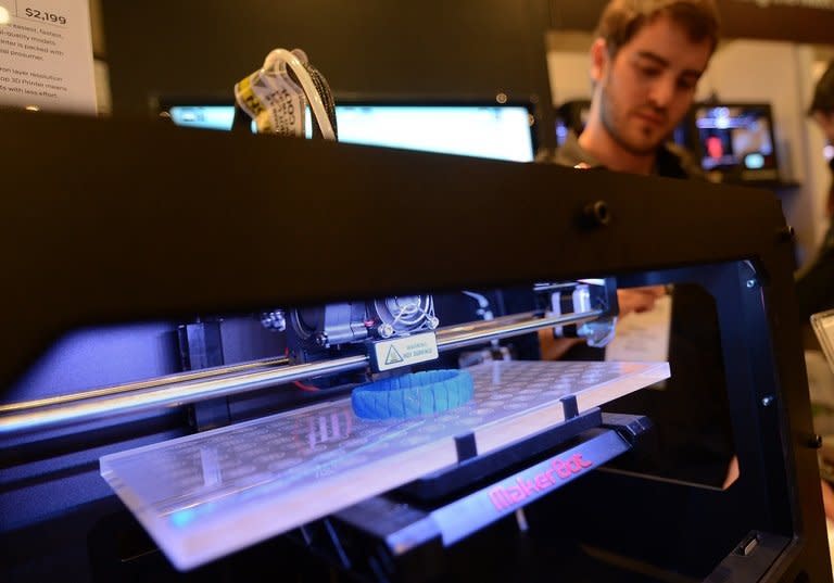 Visitors look at a 3D printer printing an object during an exhibition in New York on April 22, 2013. Computer files to create a handgun almost entirely from parts made with a 3D printer went online, alarming gun control advocates after it was successfully test-fired by its inventor