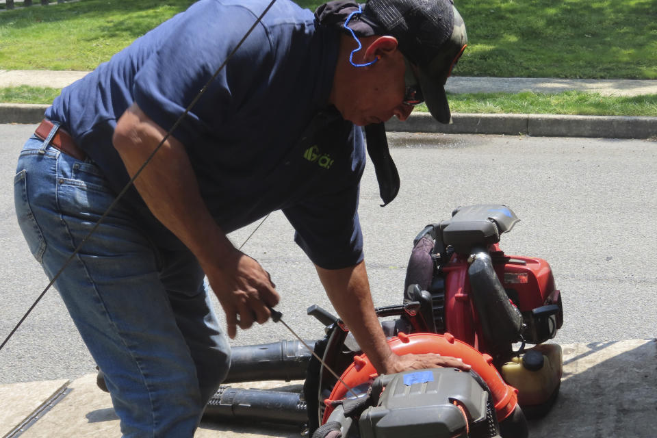 Antonio Espinoza, a supervisor with the Gras Lawn landscaping company, pulls the cord to start a gasoline-powered leaf blower in Brick, N.J. on June 18, 2024. New Jersey is one of many states either considering or already having banned gasoline-powered leaf blowers on environmental and health grounds, but the landscaping industry says the battery-powered devices favored by environmentalists and some governments are costlier and less effective than the ones they currently use. (AP Photo/Wayne Parry)