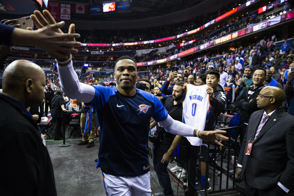 Oklahoma City Thunder guard Russell Westbrook high-fives fans as he exists the court following an NBA basketball game, Friday, Nov. 2, 2018, in Washington. The Thunder defeated the Washington Wizards 134-111. (AP Photo/Al Drago)