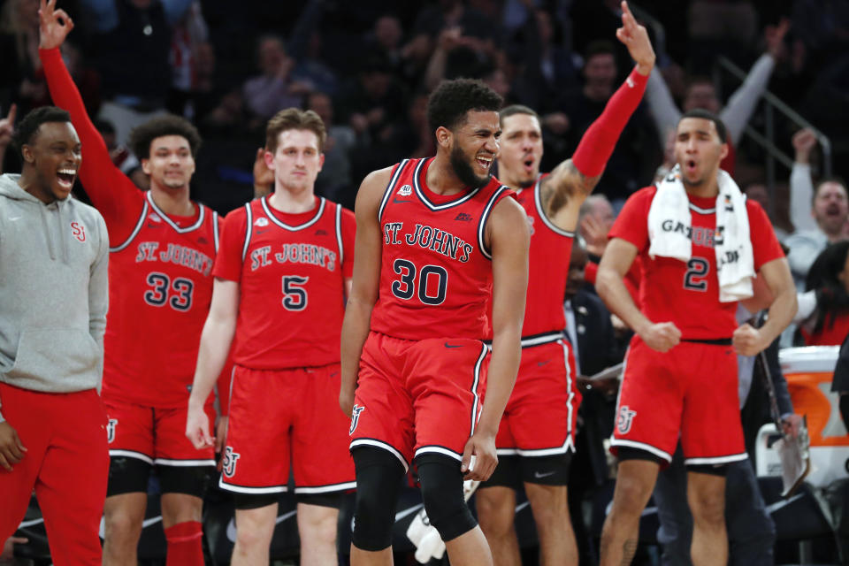 St. John's guard LJ Figueroa (30) celebrates in front of the St. John's bench after hitting a 3-pointer during the second half of the team's NCAA college basketball game against Georgetown in the first round of the Big East men's tournament Wednesday, March 11, 2020, in New York. (AP Photo/Kathy Willens)