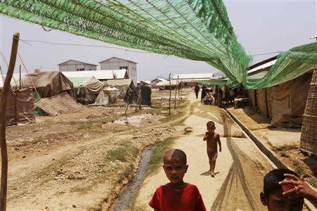 Rohingya children walk past shelters inside the Kyein Ni Pyin camp for internally displaced people in Pauk Taw, Rakhine state, April 23, 2014. REUTERS/Minzayar