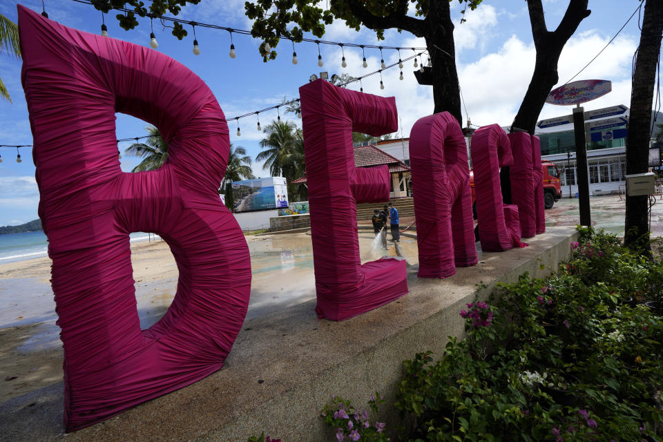 Workers spray cleaner along the frontage of Patong Beach on Phuket, southern Thailand, Tuesday, June 29, 2021. Thailand's government will begin the "Phuket Sandbox" scheme to bring the tourists back to Phuket starting July 1. Even though coronavirus numbers are again rising around the rest of Thailand and prompting new lockdown measures, officials say there's too much at stake not to forge ahead with the plan to reopen the island to fully-vaccinated travelers. (AP Photo/Sakchai Lalit)