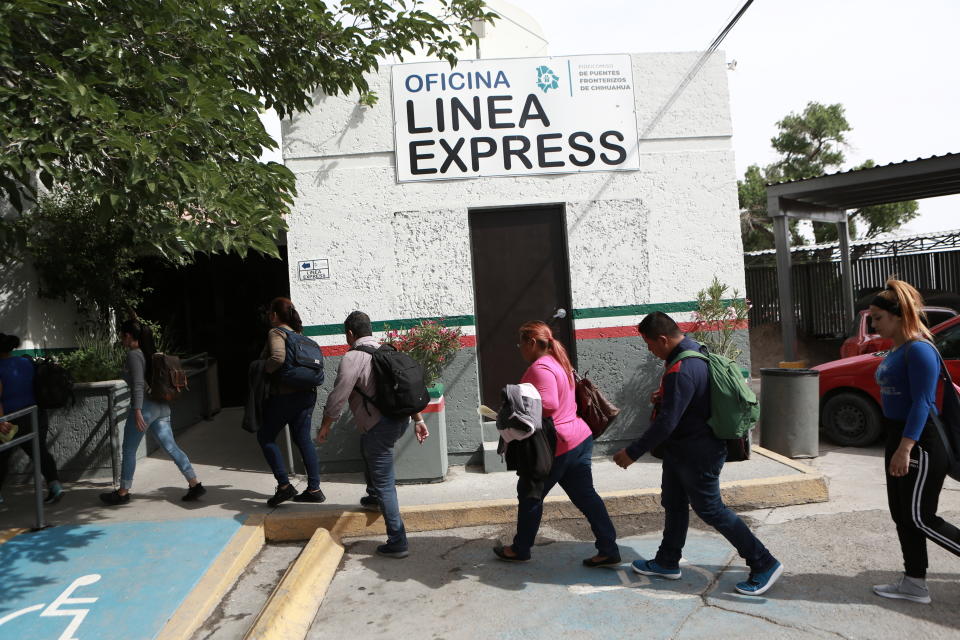 FILE - In this April 29, 2019, file photo, Cuban migrants are escorted by Mexican immigration officials in Ciudad Juarez, Mexico, to the Paso del Norte International bridge to be processed as asylum seekers on the U.S. side of the border. Hundreds of thousands of people have been arriving at the border in recent months, many of them families fleeing violence and poverty in Central America. Once they reach the border, they can take different paths to try to get into the U.S. (AP Photo/Christian Torres)