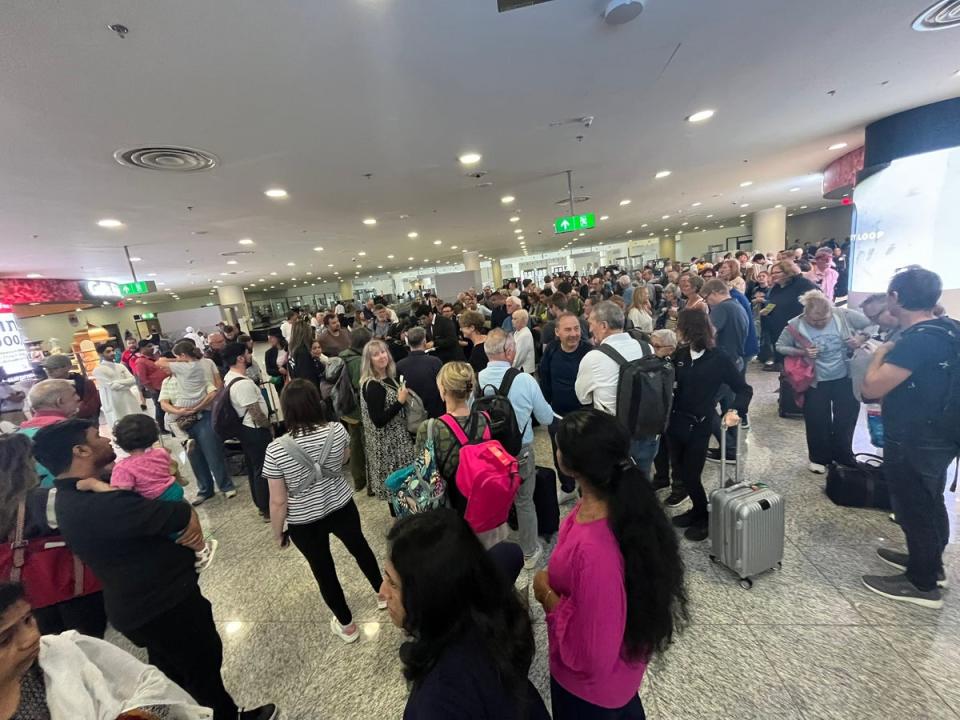 People listening to an Emirates member of staff (centre) whilst waiting at Dubai World Central airport, April 17, 2024 (Paul Lidwith/PA Wire)